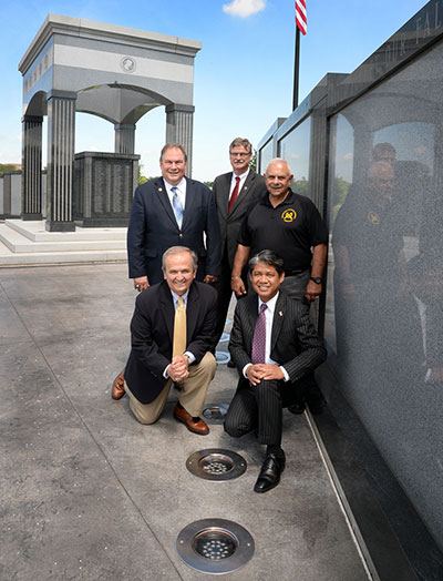 In anticipation of the upcoming Independence Day celebrations, New York Power Authority (NYPA) President and Chief Executive Officer Gil C. Quiniones (lower right) gathered with (clockwise from lower left) Senator George Maziarz, Assemblyman John Ceretto, City of Niagara Falls Mayor Paul Dyster, and David Fabrizio, Niagara Falls Veteran Memorial Committee, to visit the recently completed lighting project for the Niagara Falls Veterans Memorial in Hyde Park. Through NYPA’s support, the memorial is lit by 50 energy efficient LED light fixtures that are mounted inground. The lighting was installed by Electrical Services and System Installations of Buffalo.In anticipation of the upcoming Independence Day celebrations, New York Power Authority (NYPA) President and Chief Executive Officer Gil C. Quiniones (lower right) gathered with (clockwise from lower left) Senator George Maziarz, Assemblyman John Ceretto, City of Niagara Falls Mayor Paul Dyster, and David Fabrizio, Niagara Falls Veteran Memorial Committee, to visit the recently completed lighting project for the Niagara Falls Veterans Memorial in Hyde Park. Through NYPA’s support, the memorial is lit by 50 energy efficient LED light fixtures that are mounted inground. The lighting was installed by Electrical Services and System Installations of Buffalo.